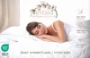 A woman sleeping peacefully on a bed with white bedding. Produktbild-Vorschau