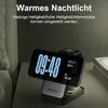 A multi-functional charging station with a digital clock display, placed on a nightstand next to a bed. Produktbild-Vorschau