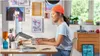 A woman is working at a desk with a laptop and keyboard. Anteprima dell’immagine prodotto