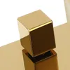 A close-up, studio shot of a gold-colored faucet handle with a cubic design. Podgląd zdjęcia produktu