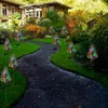 A garden path lined with solar-powered cypress tree lights. Anteprima dell’immagine prodotto