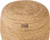 A close-up view of a round jute pouf with a leather brand tag. Náhled obrázku produktu