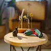 A Bosch IXO screwdriver and drill bits are arranged on a wooden table, with dried flowers in the background. Podgląd zdjęcia produktu