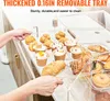 A person's hands are shown adjusting a clear acrylic display case filled with various baked goods, including muffins, cupcakes, croissants, and donuts. Náhled obrázku produktu