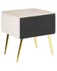 A modern bedside table with a beige velvet top and sides, a black drawer front, and gold metal legs. Náhľad obrázku produktu