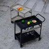 Two outdoor serving carts are shown on a gravel and paved patio. Náhled obrázku produktu