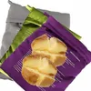 Three reusable microwave potato baking bags in different colors (purple, green, and gray) with two baked potatoes in the foreground. Produktbild-Vorschau