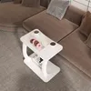 A white C-shaped side table with donuts and coffee cups on it, placed on a patterned rug next to a brown sectional sofa. Anteprima dell’immagine prodotto
