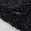 A close-up view of a black shaggy rug, showing its texture and the underside where it's folded. Anteprima dell’immagine prodotto
