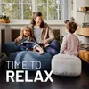 A mother and her two children are relaxing on beanbag chairs in a living room. Produktbild-Vorschau