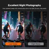 Two cyclists riding at night with city lights in the background, showing a comparison of low noise vs high noise photography. Produktbild-Vorschau
