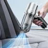A hand holding a portable vacuum cleaner and cleaning a car seat. Produktbild-Vorschau