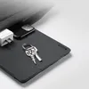 A dark gray tablet case is shown with a smartphone, charger, and keys placed on it, partially tucked into a bag. Produktbild-Vorschau