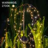 A solar-powered garden light with LED lights shaped like a weeping willow tree, set amongst ferns at night. Anteprima dell’immagine prodotto