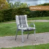 A garden chair cushion is placed on a garden chair in a garden setting. Produktbild-Vorschau