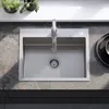 A stainless steel kitchen sink with a faucet, set on a stone countertop. Podgląd zdjęcia produktu
