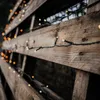 A close-up shot of string lights wrapped around wooden planks. Produktbild-Vorschau