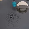 Water droplets on a dark surface with a blue faucet and a close-up of a black mesh basket with a lid. Produktbild-Vorschau