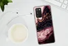 A smartphone case with a marble design is placed on a white surface next to a cup of coffee and earphones. Produktbild-Vorschau