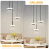 Two side-by-side images showing a set of three modern pendant lights hanging over a table in a living room setting. Anteprima dell’immagine prodotto