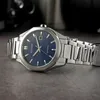 A close-up shot of a Citizen Eco-Drive watch with a blue dial and silver metal band, resting on a textured gray surface. Náhled obrázku produktu