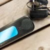 Close-up of a power bank with a blue light and a charging adapter in the background. Produktbild-Vorschau