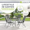 A garden furniture set with a table and four chairs is shown on a patio, with a background of a garden and a building. Produktbild-Vorschau