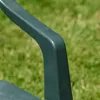 A close-up shot of a green plastic chair armrest with a blurred green lawn in the background. Náhled obrázku produktu