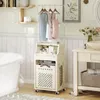 A bathroom scene with a laundry cart, bathtub, and vanity. Náhled obrázku produktu