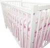 A close-up view of a white baby crib with pink bedding. Produktbild-Vorschau