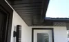 A close-up view of the exterior of a house, showing soffit panels, a window frame, and a wall-mounted light fixture. Produktbild-Vorschau