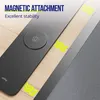 A close-up view of a black laptop pad with a circular magnetic charging area, placed on a wooden surface. Yellow wavy lines indicate magnetic attraction. Produktbild-Vorschau