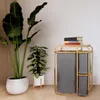 A bamboo laundry basket with three gray fabric bags is placed next to two potted plants in a room. Produktbild-Vorschau