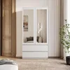 A white wardrobe with mirrored doors and drawers in a room. Produktbild-Vorschau