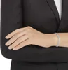 A person wearing a black blazer and a silver tennis bracelet. Produktbild-Vorschau