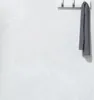 A gray towel hanging on a white coat rack mounted on a textured light gray wall. Podgląd zdjęcia produktu