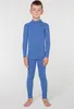A young boy is standing and modeling a blue thermal underwear set. Náhľad obrázku produktu