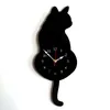 A black cat-shaped wall clock with a pendulum tail, set against a white background. Produktbild-Vorschau