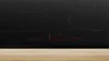 A close-up shot of a black induction cooktop with red digital displays. Podgląd zdjęcia produktu