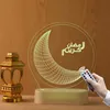A decorative LED lamp with a crescent moon and Arabic calligraphy, along with a golden lantern, on a wooden surface. Produktbild-Vorschau