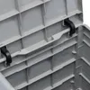 Close-up view of the inside of a grey plastic storage box, showing the lid mechanism and internal structure. Náhled obrázku produktu