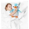 A child sleeping in bed with a stuffed penguin toy. Voir les images du produit