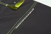 A close-up view of a dark gray fabric with bright yellow stitching and a reflective strip. Produktbild-Vorschau