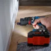 A person is using a cordless drill to screw into a baseboard. Náhled obrázku produktu