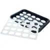 A baking tray with small, round, white cookies and a white plastic mold for making cookies. Produktbild-Vorschau