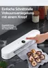 A person's finger is pressing a button on a white vacuum sealer machine which is sealing a bag of dried mushrooms. Produktbild-Vorschau