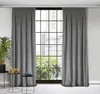 A pair of gray curtains hanging in front of a large window with a city view. Produktbild-Vorschau