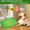 A dog is lying on a wooden floor next to a green mop with a silver handle. The background shows a window and a wall. There are circular images above the mop showing different types of debris. Produktbild-Vorschau