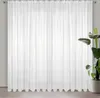 A white sheer curtain hanging in front of a window. Produktbild-Vorschau