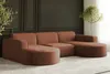 A modern sectional sofa in a living room setting with decorative wall paneling and a potted plant.